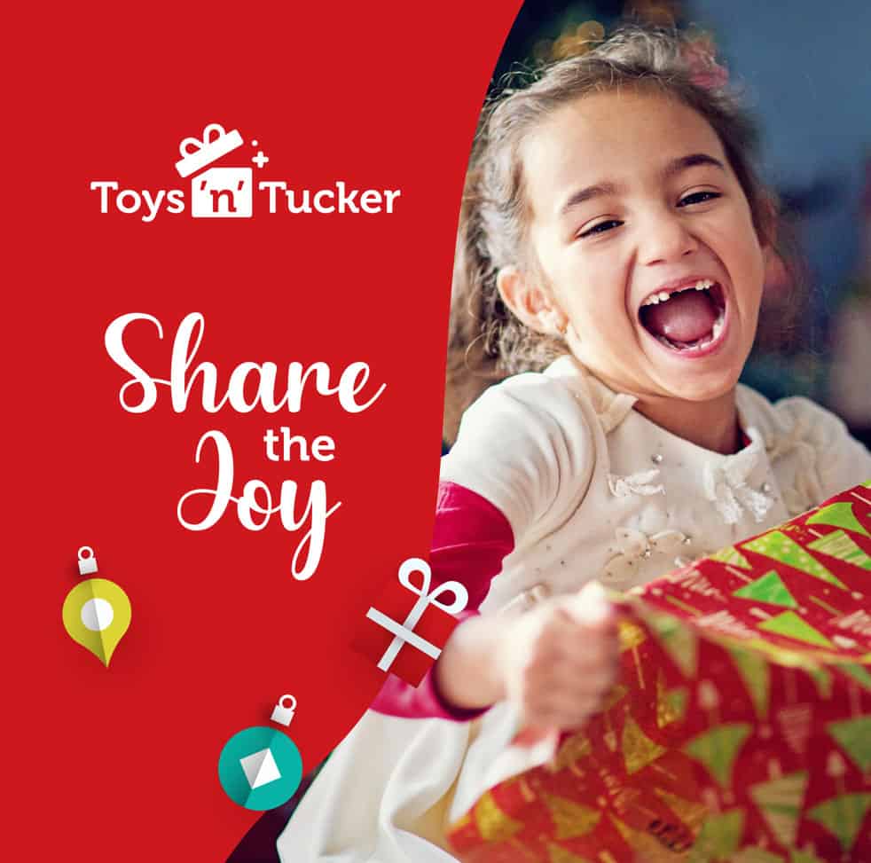 A girl laughing while opening a present